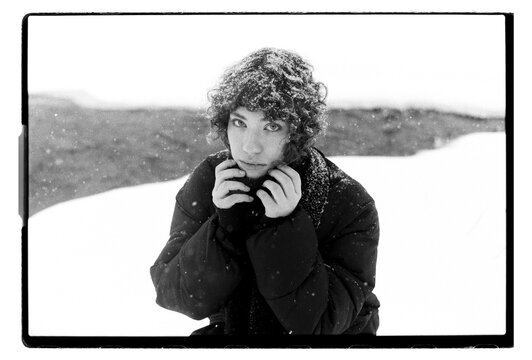 
Film B&W Portrait of a Woman Clutching Jacket Collar in Blizzard