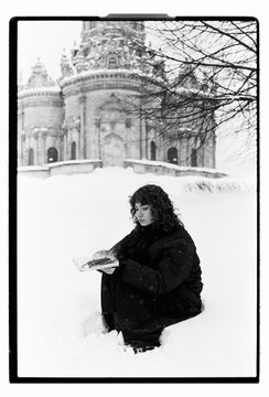 Film B&W Portrait of a Woman Sitting in Snow by Baroque Church
