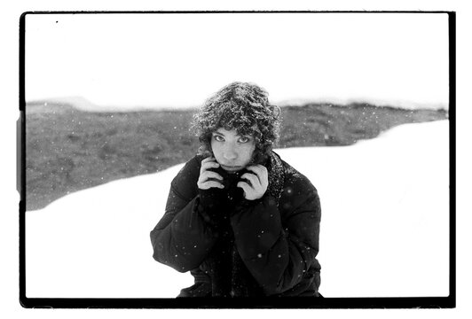 
Film B&W Portrait of a Woman Clutching Jacket Collar in Blizzard