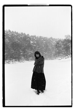 Film B&W Portrait of a Woman Raising Arm in Snowy Field
