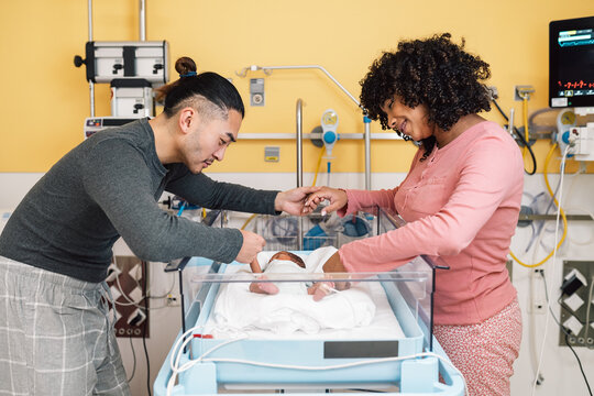 Parents bonding with newborn baby in hospital