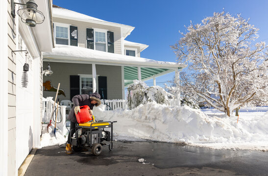 Man operating generator home after snow storm  