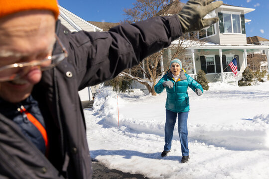 Senior couple winter throw snowball fight 