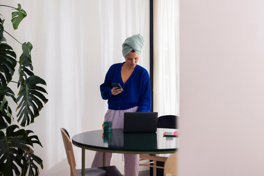 Woman Working From Home With Laptop And Phone