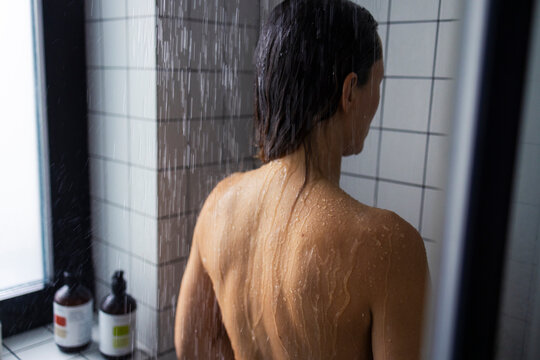 Woman Showering In Modern Bathroom