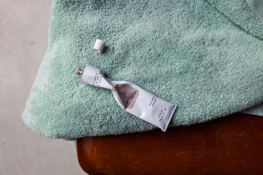 Squeezed Hand Cream Tube on Mint Towel and Leather