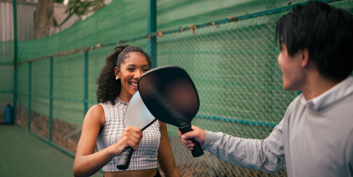 Young diverse friends enjoying pickleball match win hitting rackets