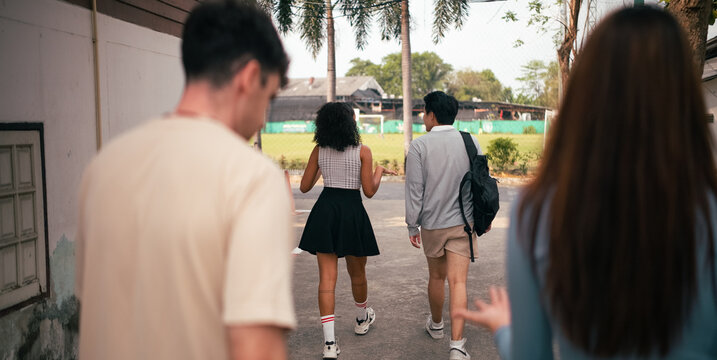 Diverse students walking together on multi sports court to play