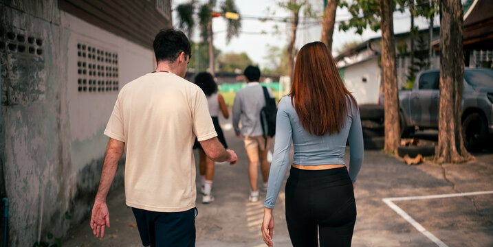 Young friends walking along street together in an ally in Bangkok