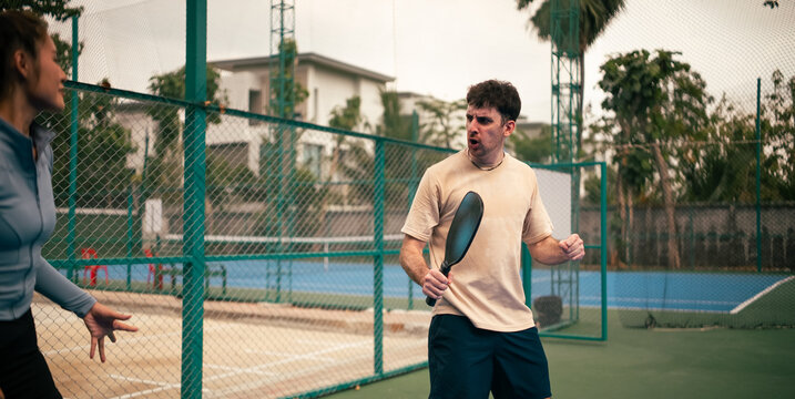 Teammates celebrating a win on a pickleball match on outdoor court