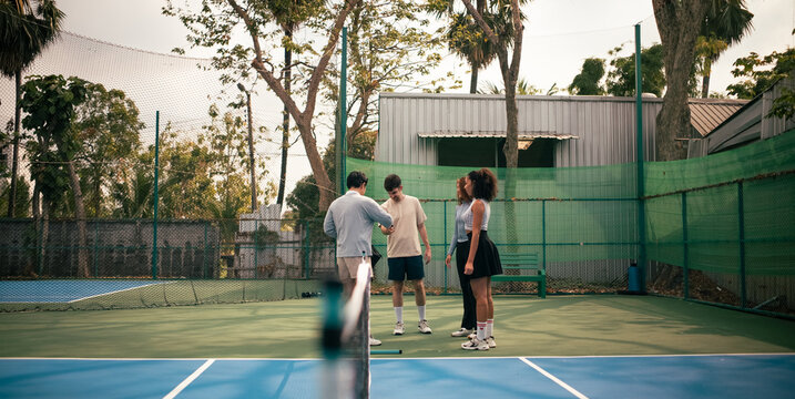Young friends discussing strategy on a pickleball court before match