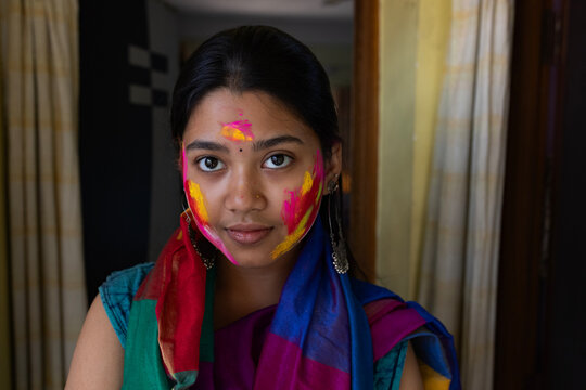 Young Indian lady face smudged with colourful powders in holi festival