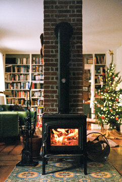 Cozy living room decorated for Christmas with fire in the wood stove