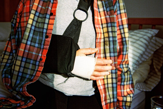 Anonymous detail of woman with arm in sling, captured on film