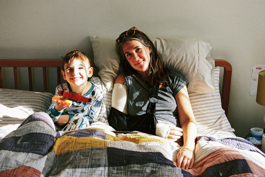 Candid film portrait of child and his injured mother in bed