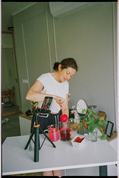 Woman glazing mousse cake while filming content