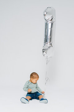 A kid with a silver balloon.