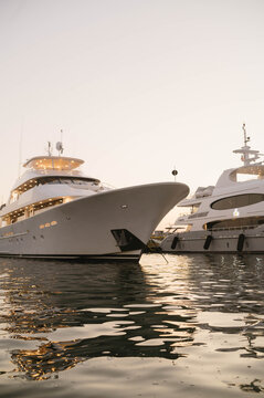Luxury yachts docked in Nantucket harbor at sunset