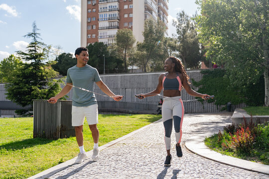 Fitness enthusiasts jumping rope in the sunny park