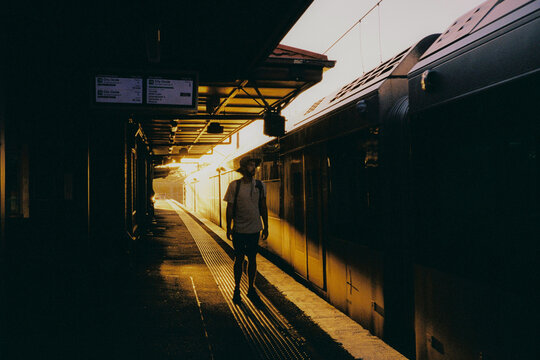 Man stands on the train platform in warm light 