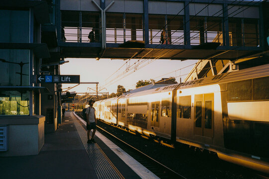 Man stands on the train platform in warm light 