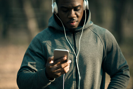 Man listening to music on smartphone outdoors in park