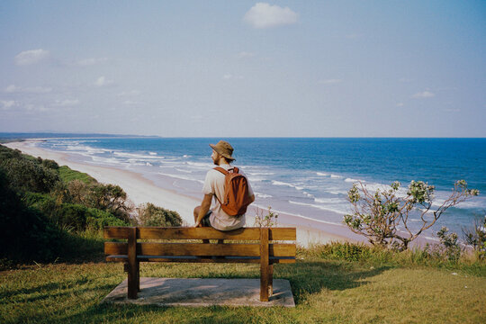Man sits on the bench overlooking the beach in NSW, Australia 