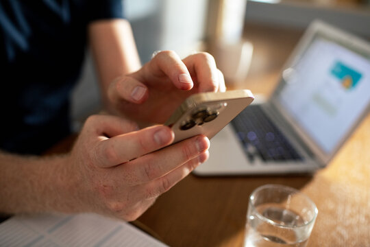 Close-up of hands using smartphone at home office desk