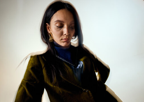 Woman in a blazer and blue scarf in a studio setting