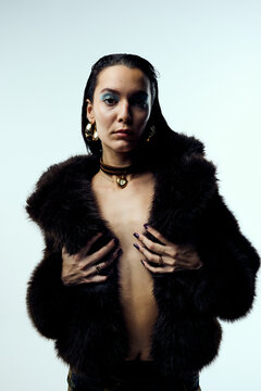 Sensual woman is wearing a fur coat in studio