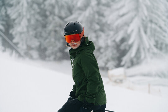 A skier standing in a snow-covered forest at a ski resort