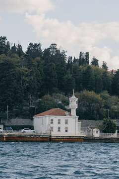 La hist&oacute;rica mezquita Uryanizade Ahmet Mesut Efendi, una singular estructura de madera blanca situada a orillas del B&oacute;sforo en Kuzguncuk, Estambul, enmarcada por un denso bosque verde.