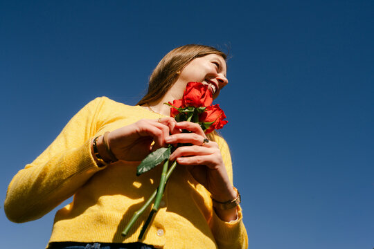 young woman holding red roses 