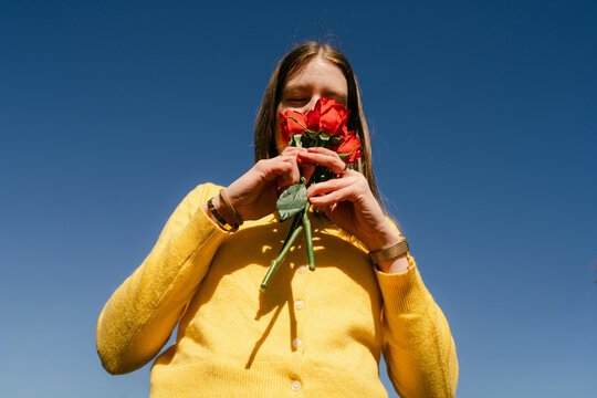 young woman smelling roses 