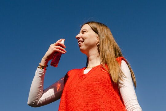 young woman with perfume spray bottle 