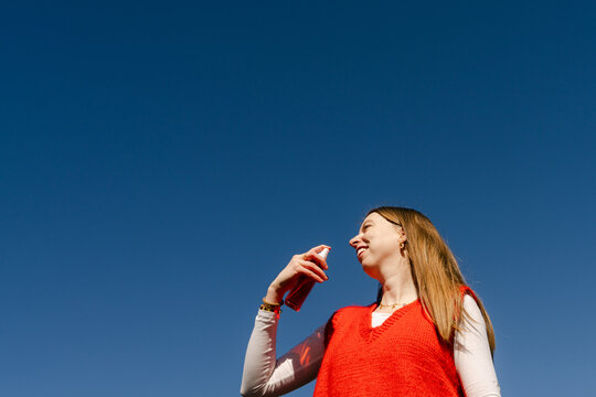 young woman with perfume spray bottle 