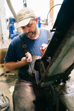 Craftsman sharpening knife blade on grinding machine