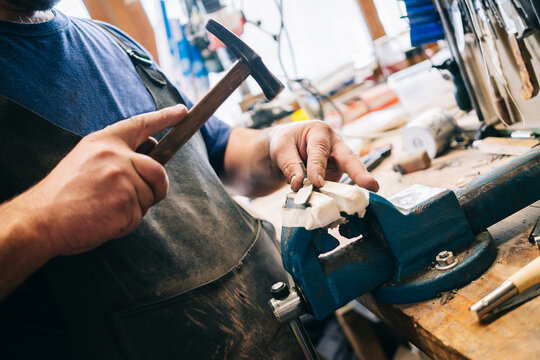 Craftsman hammering knife handle creating custom blade