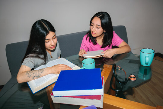 Two Female Classmates Reading Textbook Together
