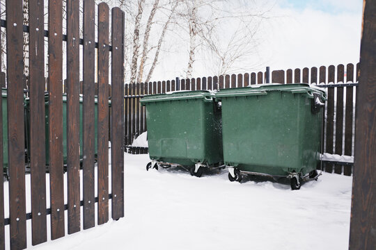 Green waste containers standing in deep winter snow