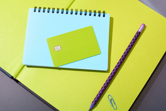 Green card, notebook, and pencil on a table