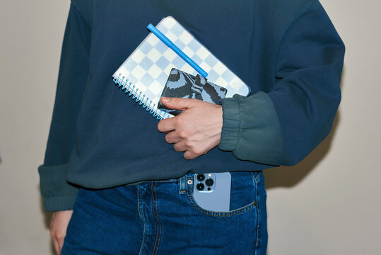 Woman holding smartphone and wallet with notebook