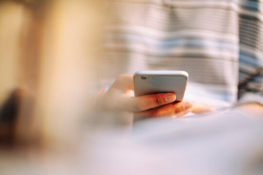Woman hands using phone, depth of field effect, background focus