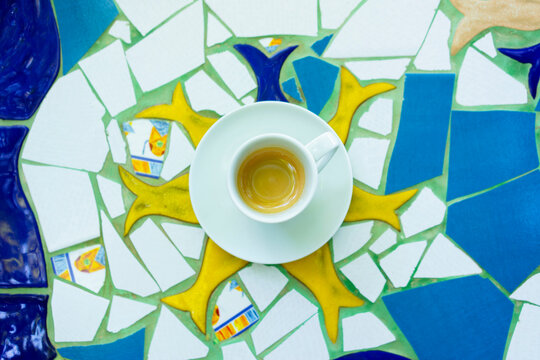 From above shot, cup of espresso on fish shaped mosaic tile table