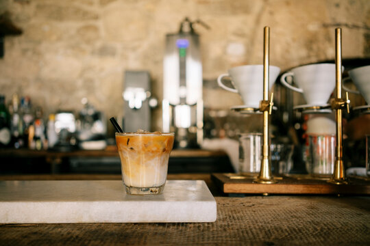A glass of iced latte on the counter of a coffee shop