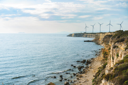Windmills on the cliffs of Bozcaada, Turkey under blue sky