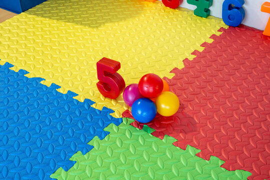 Number five in red and colorful balls on a foam playmat