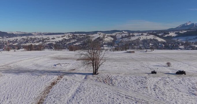 Winter aerial panorama of the Tatra Mountains and snow covered fields under clear blue sky