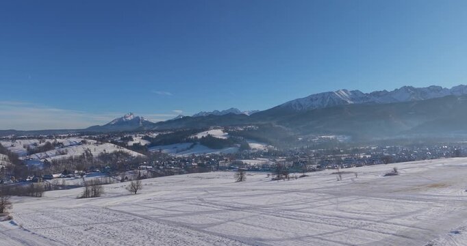 Aerial winter view of Zakopane with Tatra Mountains and snow covered fields
