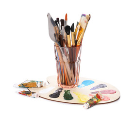Fototapeta na wymiar Paintbrushes with knife in glass, paints and palette isolated on white
